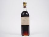 une vieille bouteille de vin posée sur une surface blanche