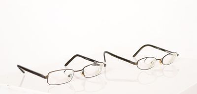two pairs of glasses sitting on top of a white surface