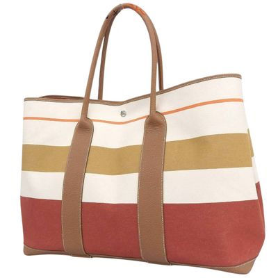 a large striped tote bag sitting on top of a white surface