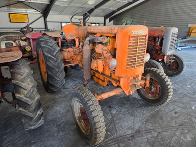 many old tractors parked in a garage together
