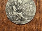 an old silver coin sitting on top of a wooden table