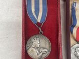 two medals are in a red box with a ribbon around them