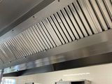 un homme debout dans une cuisine devant une cuisinière