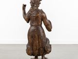 an image of a wooden statue of a woman holding a bird