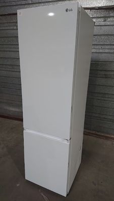 un réfrigérateur blanc dans un entrepôt, dont la porte est ouverte