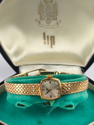 an image of a woman ' s watch in a box on a table
