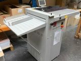 La machine est posée par terre dans l'entrepôt.