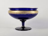 un bol en verre bleu orné d'un motif doré