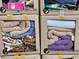 Plusieurs cartons de vêtements sont empilés les uns sur les autres