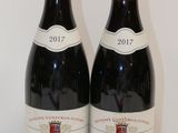 deux bouteilles de vin posées sur une table l'une à côté de l'autre