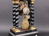 a clock that is sitting on a stand on a table