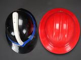 a red hard hat and a black hard hat next to each other