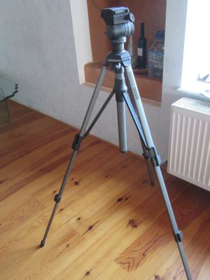 un appareil photo posé sur un trépied dans un coin de la pièce