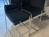 pair of black leather and chrome bar stools in the shape of a pair of chairs