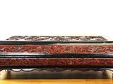 une boîte noire et rouge posée sur une table en bois