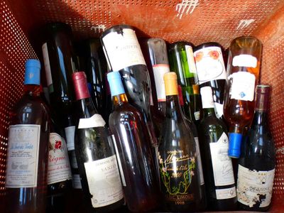 plusieurs bouteilles de vin dans un panier posé sur la table