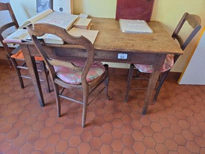 a wooden table with chairs and a book on top of it
