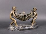 a bronze sculpture of two men carrying a large object