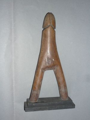 une sculpture en bois représentant une tête de cheval, posée sur une étagère