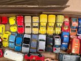 a lot of toy cars in a box on the floor