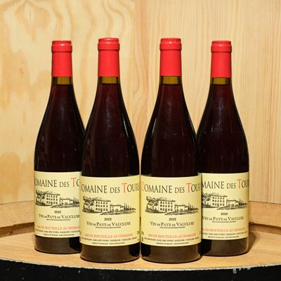 three bottles of wine sit on a wooden barrel in front of a wooden wall