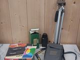une table sur laquelle se trouvent un appareil photo, un étui pour appareil photo et d'autres objets