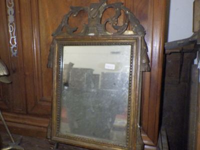 a mirror sitting on the floor next to a lamp