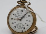 a small gold pocket watch with a chain around it