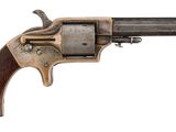 un vieux revolver avec un manche en bois sur fond blanc