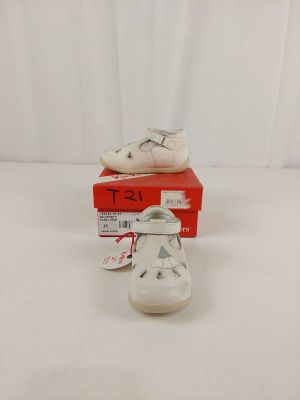 pair of white baby shoes sitting on top of a red box