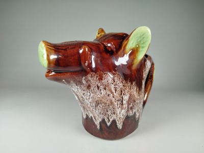 a brown and green vase with a bear head on it