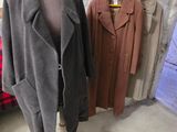 deux manteaux posés sur un présentoir à mannequin dans une pièce