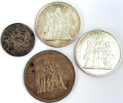quatre types de pièces différents posés sur une surface blanche