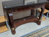 une table avec un plateau en marbre et une chaise placée devant