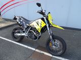 une moto tout-terrain jaune et noire garée sur un parking