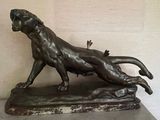 a bronze statue of a lion on a marble base