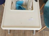 a baby high chair with a tray on the floor