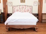 an image of a bed in a bedroom with wood floors