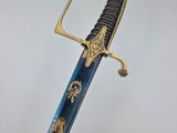 a close up of a blue and gold sword on a white background