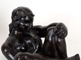 statue d'une femme assise sur le ventre sur une surface blanche