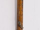 a wooden stick with a metal handle hanging on a wall