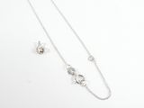 un ensemble composé d'un collier et de boucles d'oreilles en argent, posé sur une surface blanche
