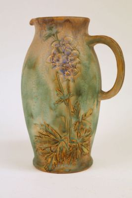 un vase vert orné d'une fleur violette