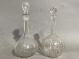 two glass vases sitting next to each other on a table