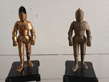 two gold figurines of a man and a woman