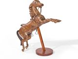 statue représentant un homme à cheval, posée sur un socle en bois