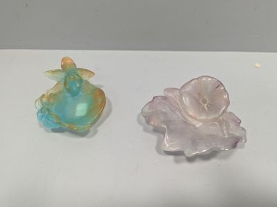 deux petites figurines en verre posées sur une table