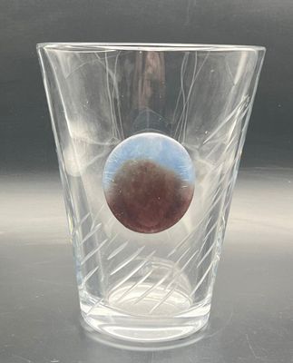 a clear glass with a brown eye inside of it