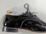 someone is wearing a pair of black shoes with laces on them