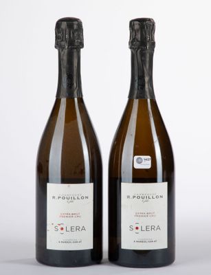 deux bouteilles de vin posées l'une à côté de l'autre sur une surface blanche